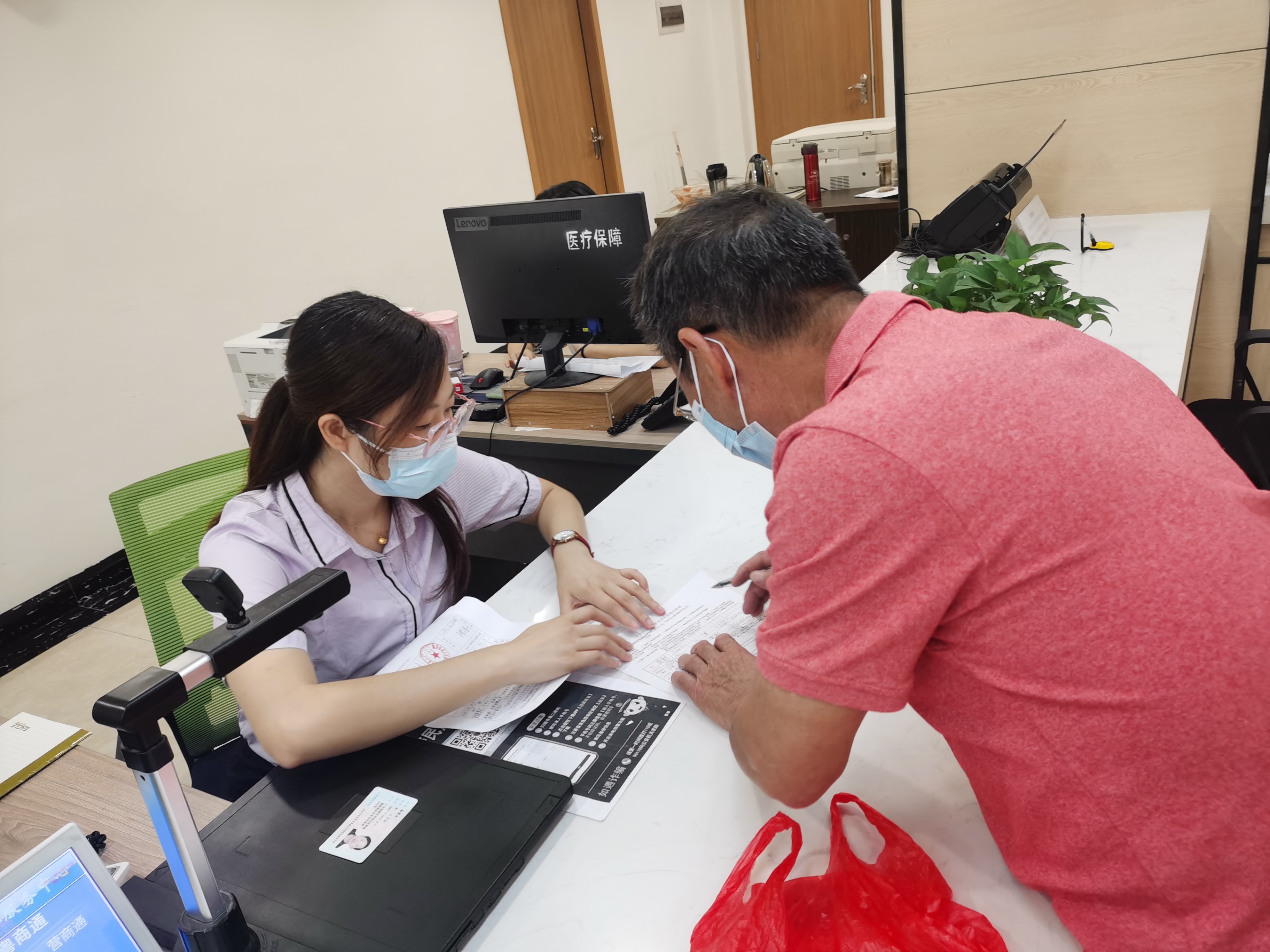 区社保综合服务窗口工作人员为办事群众提供服务.jpg