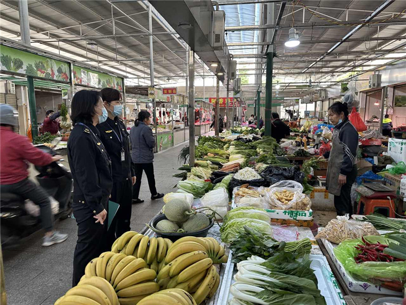 执法人员在荣华市场对蔬菜价格进行检查.jpg