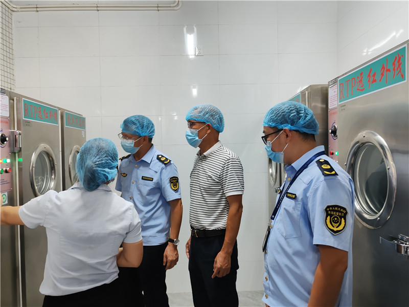 执法人员在韶州中学检查消毒柜消毒温度及时间是否符合标准.jpg