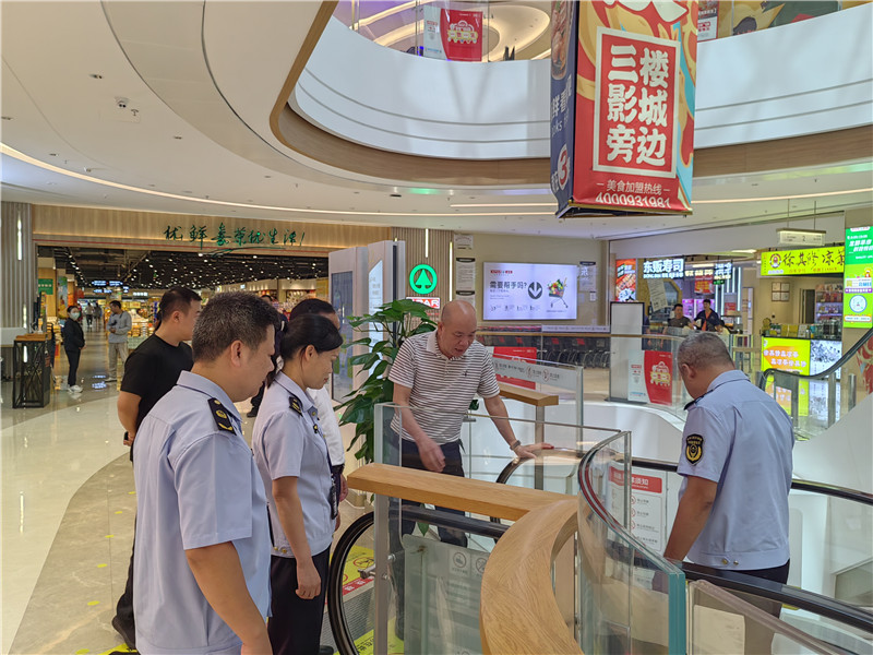 执法人员检查商场在用自动扶梯运行情况.jpg