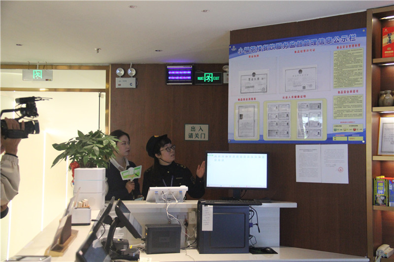 执法人员检查餐馆信息公示栏.jpg