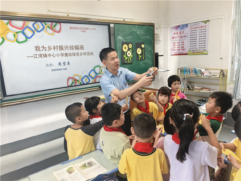 周碧库向一年级学生示范剪花朵的步骤.jpg