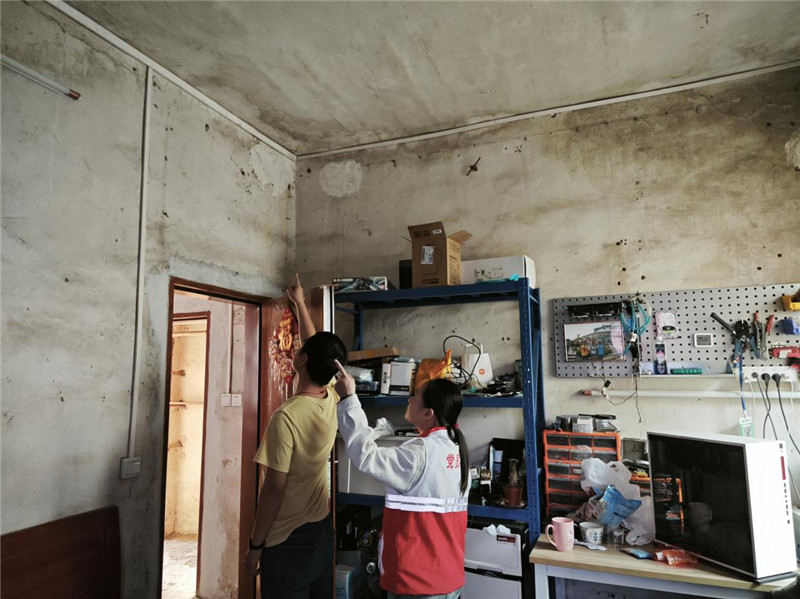 社区工作人员到林大哥家了解情况.jpg