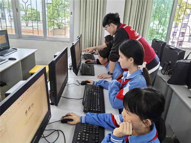 志愿者指导孩子们使用电脑软件创作作品.jpg