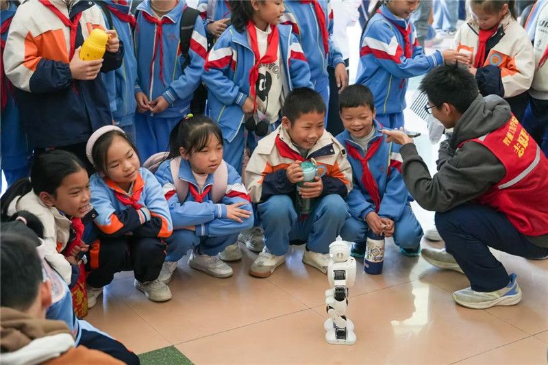 孩子们在志愿者的引导下尝试对机器人发出指令.jpg