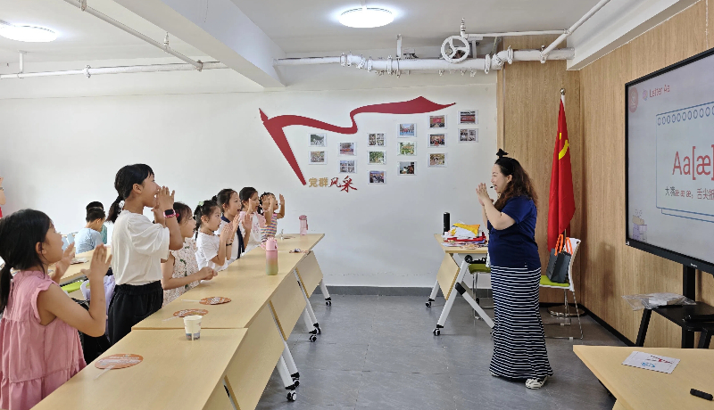 志愿者带领孩童进行暑假爱心托管班学习活动.jpg